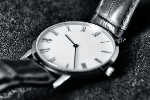 A white Roman-numeral dial on black leather.