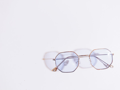 Hexagonal wire frames casting a shadow on white.