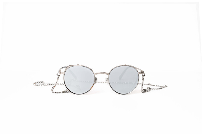 Round mirrored sunglasses on a fine chain.