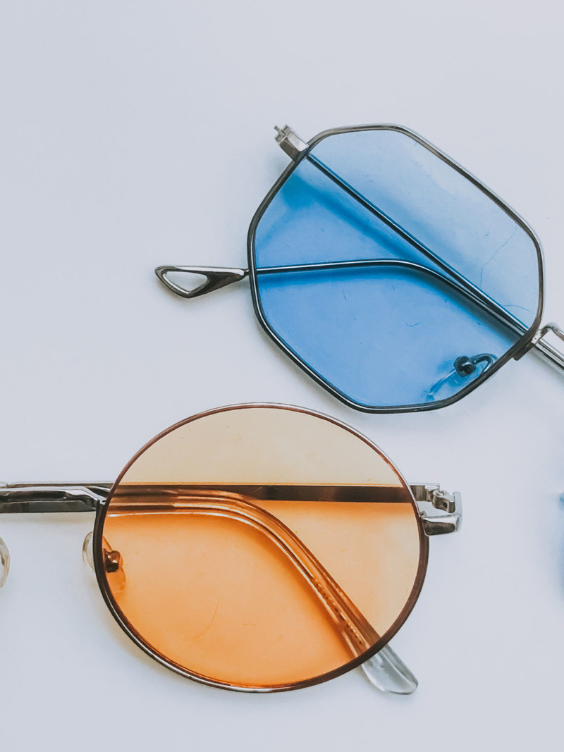 Geometric metal sunglasses with blue and amber lenses.